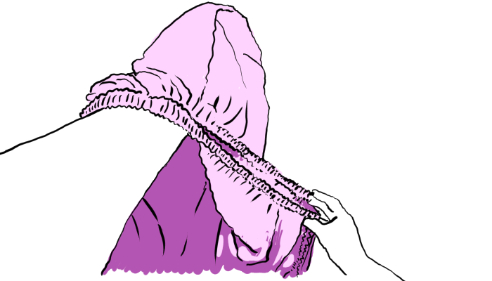 Left arm is in the pocket of the corners and the right arm is tugging the two elastic edges together.