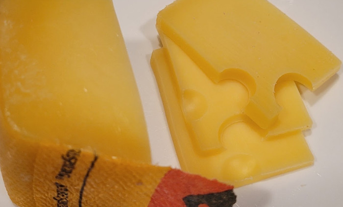 Photo of cheese with slices and a bit of the colorful outer wax covering