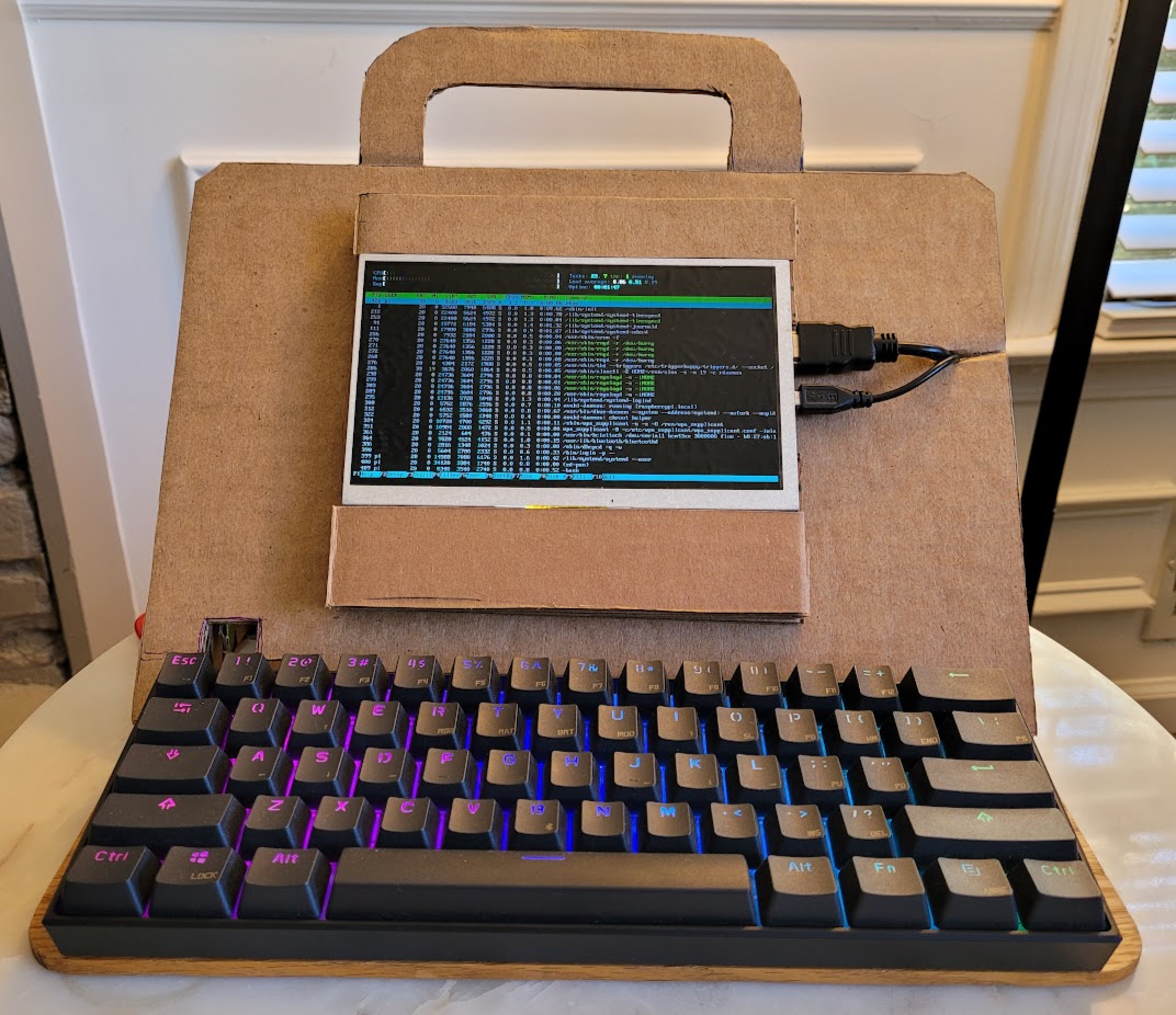 a front view of my raspberry pi zero-powered cardboard laptop luggable computer running htop