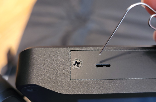paperclip hovering over the standby switch slot