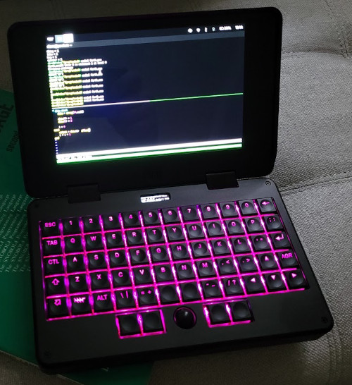 mnt pocket reform laptop computer sitting on the snobol4 green book